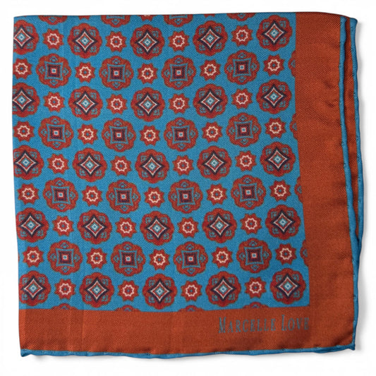 Patterned fabric square with blue and orange colors and 'Marcelle Love' branding.
